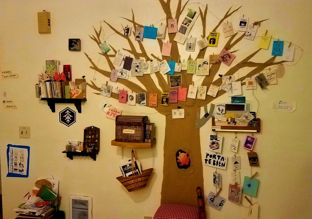 paper cut-out in the shape of a tree with zines hanging from its branches